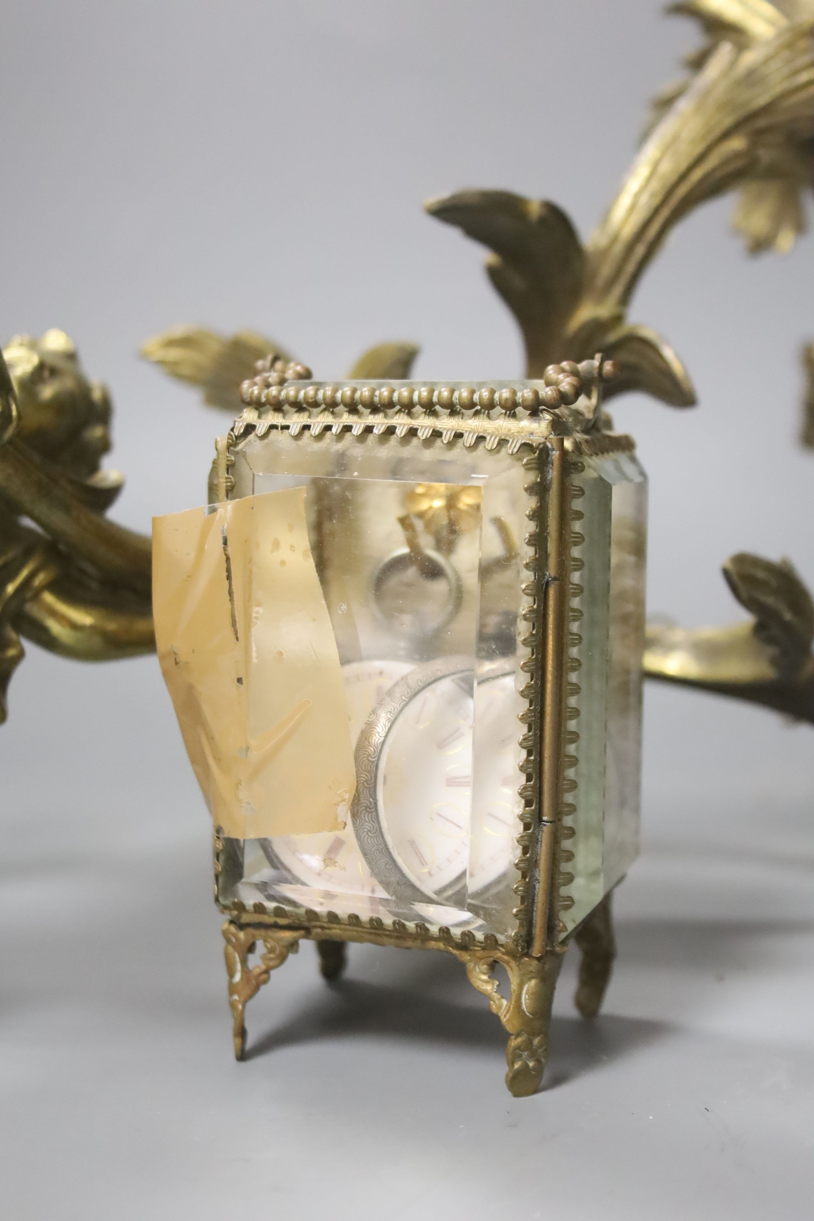 A brass carriage timepiece, a brass casket containing silver watch and a brass rococo-style twin-sconce wall light
